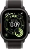 A close-up of an Apple Watch Ultra with a black and gray trail loop band, displaying a watch face with various metrics. Produktbild-Vorschau