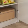 A close-up view of a cabinet interior, showing a cardboard box on a shelf and a cabinet hinge. Podgląd zdjęcia produktu