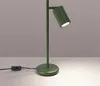 A green desk lamp is shown on a surface against a plain background. Voir les images du produit