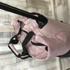 A close-up view of a pink duffel bag with black accents, showing its quilted pattern and zippered compartments. Produktbild-Vorschau
