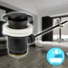 A black pop-up drain assembly for a sink, shown in a bathroom setting. Produktbild-Vorschau