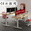 Two adjustable standing desks are set up in an office environment with monitors and chairs. Podgląd zdjęcia produktu