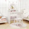 A child's white vanity table and chair set in a bedroom, with a bed and a smaller bed visible. Náhled obrázku produktu