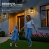 A woman and a child are dancing on a lawn in front of a house at dusk, illuminated by outdoor lights. Produktbild-Vorschau