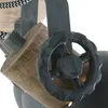 Close-up of a decorative industrial-style lamp fixture, showing a wooden block and a metal gear-like wheel. Anteprima dell’immagine prodotto