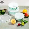 A set of glass food containers with lids, surrounded by fresh fruits and vegetables. Produktbild-Vorschau