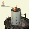 A charcoal chimney starter with burning coals on top, placed inside a grill. Produktbild-Vorschau