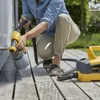 A person is using a paint sprayer on a wooden deck outdoors. Anteprima dell’immagine prodotto