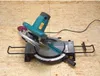 A miter saw is placed on a wooden surface. Podgląd zdjęcia produktu