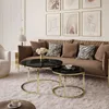 A living room scene with a sofa, coffee tables, and artwork. Náhled obrázku produktu