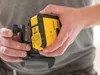 A person is holding a yellow and black laser level tool. Produktbild-Vorschau