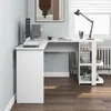 A white L-shaped desk with shelves is shown in a room with a window and a radiator. Anteprima dell’immagine prodotto