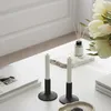 Two white LED candles in black holders are placed on a white table next to a stack of books and a vase of white tulips. A bottle of diffuser with reeds is also visible. Produktbild-Vorschau