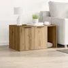 A wooden cabinet with two doors and an open shelf, next to a sofa. A lamp, books, and a plant are on top of the cabinet. Produktbild-Vorschau
