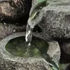 Water flowing over rocks into a basin. Produktbild-Vorschau
