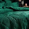 A close-up view of emerald green velvet bedding with a palm leaf pattern. Voir les images du produit