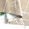 A close-up view of a beige curtain with a white abstract pattern, showing the texture and stitching. Produktbild-Vorschau
