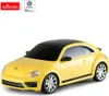 A yellow Volkswagen Beetle toy car with a black roof and tinted windows, shown from a three-quarter front angle on a white background. Náhled obrázku produktu