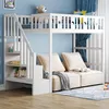 A white bunk bed with a sofa underneath, set in a child's bedroom with blue walls and curtains. Produktbild-Vorschau
