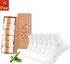 A product shot of socks in packaging and loose on a white background, with a small bamboo accent. Produktbild-Vorschau
