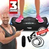 A man points to a vibration plate with a person standing on it, along with accessories. Produktbild-Vorschau