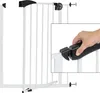 A white metal baby gate with a black latch mechanism is shown, with an inset close-up of a hand operating the latch. Náhľad obrázku produktu