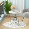 A round, two-tiered side table with gold legs is placed on a rug on a wooden floor, next to a potted plant and a chair. Anteprima dell’immagine prodotto