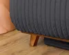 A close-up view of the base of a dark gray, ribbed armchair with wooden legs, resting on a wooden floor. Produktbild-Vorschau