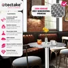 A small round table with a metal top and a single metal leg, set in a cafe or restaurant environment. The table has drinks and a vase of flowers on it. The image also includes promotional text and icons highlighting the product's features. Náhled obrázku produktu