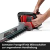 Hands holding a red and black hedge trimmer with a close-up of the blade. Produktbild-Vorschau