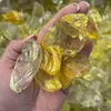 Gelber Glassplitt auf einer Handfläche zur Größendarstellung Produktbild-Vorschau