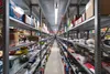 A long aisle in a warehouse filled with shelves of products. Produktbild-Vorschau
