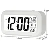 A white digital alarm clock with a digital display showing the time, date, and temperature, along with dimensions indicated by lines and text. Voir les images du produit