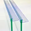 Close-up view of two clear plastic shower door seals with green inserts, with water droplets on them, against a white background. Produktbild-Vorschau