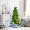 A decorated Christmas tree in a living room setting with a fireplace and sofa. Voir les images du produit