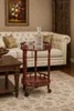 A wooden bar cart with a decanter and glass on it, placed in a living room setting next to a sofa. Produktbild-Vorschau