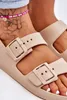 Close-up of a person's feet wearing beige sandals with buckles and an anklet. Produktbild-Vorschau