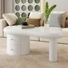 A modern living room with a white coffee table, sofa, and decorative wall art. Voir les images du produit