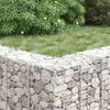 A gabion planter filled with rocks, with grass and bushes in the background. Produktbild-Vorschau