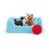 Two toy cats in a blue bed with a ball of red yarn. Anteprima dell’immagine prodotto