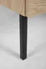 A close-up of a black metal furniture leg attached to a wooden cabinet. Produktbild-Vorschau