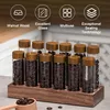 A set of 12 glass storage tubes with wooden lids, filled with coffee beans, arranged on a wooden stand. Produktbild-Vorschau