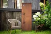 A garden scene with a wicker chair and a decorative metal screen. Produktbild-Vorschau