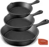 A stack of three black cast iron skillets of varying sizes, with a small orange silicone scraper in the bottom right corner. Produktbild-Vorschau