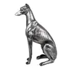 A silver-colored statue of a greyhound dog sitting, viewed from the side. Náhled obrázku produktu