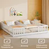 Two white children's beds with guardrails are shown side-by-side in a room with light-colored walls and yellow curtains. Anteprima dell’immagine prodotto