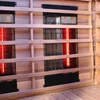 Close-up view of the interior of an infrared sauna, showing the heating elements and wooden interior. Produktbild-Vorschau