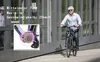 A man is riding an e-bike in front of a large metal gate. An inset image shows the e-bike's motor. Produktbild-Vorschau