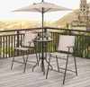 A bistro set with an umbrella and two chairs on a balcony overlooking a city and a castle. Podgląd zdjęcia produktu