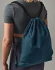 A person wearing athletic clothing and a teal gym bag. Produktbild-Vorschau